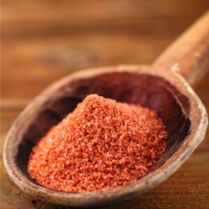 Red spice on wooden spoon
